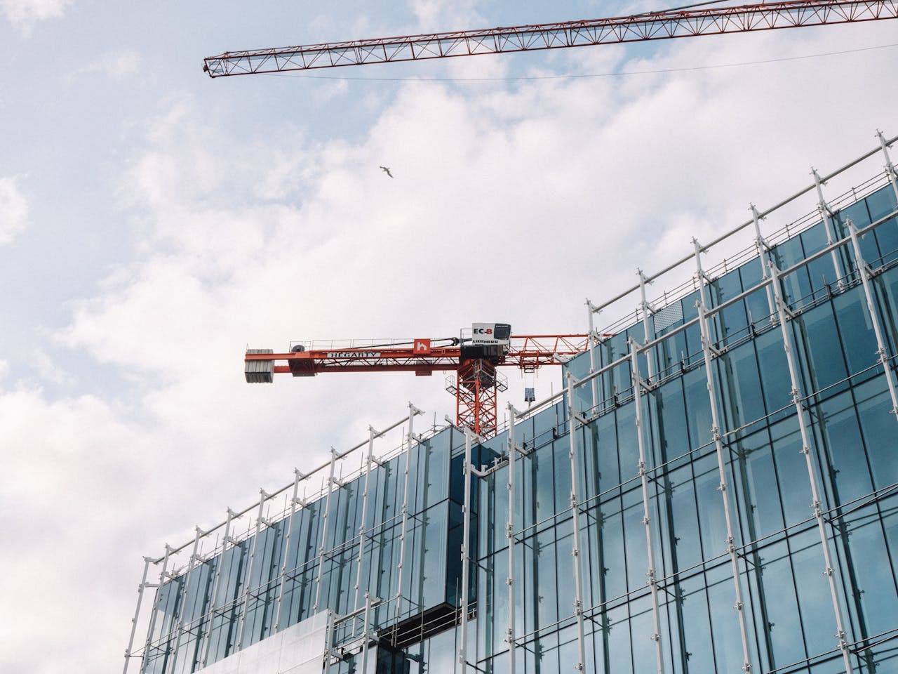 heros-img Architectural view of modern building under construction with crane, showcasing Dublin's urban development.